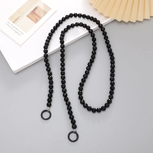 Close-up of black faceted bead crossbody strap with sturdy silver metal ring connectors