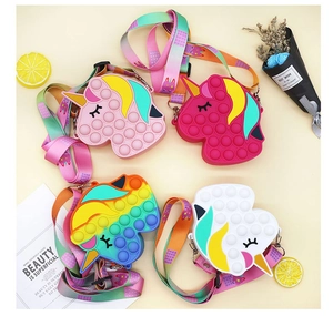 Detailed view of four colorful unicorn pop-it silicone bags with rainbow shoulder straps