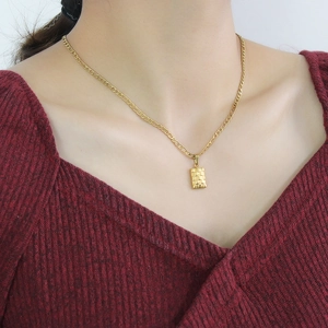 18K gold necklace with minimalist checkered heart rose pendant on wine red sweater