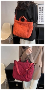 Detail of orange and burgundy quilted nylon tote bags with adjustable straps in a lifestyle setting