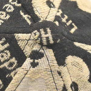 Macro detail of the crown on a jacquard baseball cap with woven patterns and top button