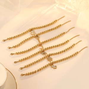 Golden beaded charm bracelet set featuring bear, moon, and star pendants for women