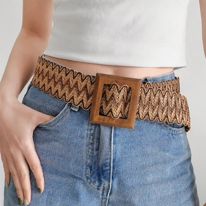 Detail of bohemian woven belt with square wooden buckle on blue denim jeans