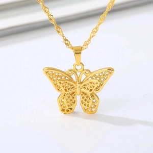 Detailed close-up of a golden filigree butterfly pendant with an elegant singapore chain
