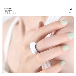 Minimalist white ceramic ring on model finger with elegant 18k gold plated detail