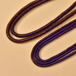 Macro shot of purple rainbow hematite disc beads with metallic luster for DIY jewelry