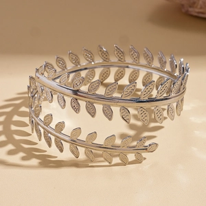 Detail of silver leaf arm cuff with delicate openwork foliage and artistic lighting