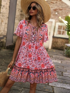 Detail of pink bohemian floral dress showing V-neckline and lightweight printed fabric