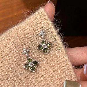 S925 silver needle clover earrings with green zircon and pearls on knit background