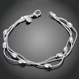 Macro shot of silver-plated triple-strand bracelet with polished olive-shaped beads