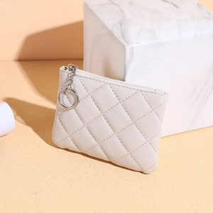 Close-up of white quilted leather coin purse with silver zipper and keychain ring