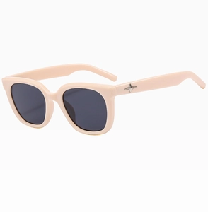 Detail of cream square sunglasses featuring silver star emblem and dark lenses