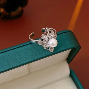 Macro shot of silver ring with large round pearl and sparkling zircon floral detail