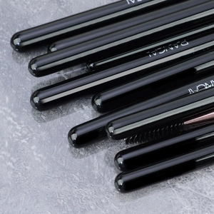 Detailed close-up of a black glossy makeup brush handle with RANCAI logo and spoolie brush