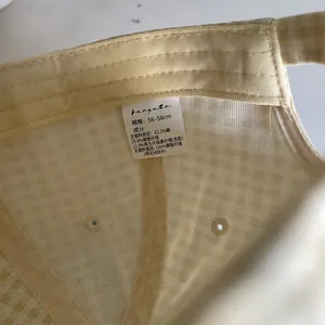 Detail showing inner fabric label and stitching of a plaid pattern baseball cap