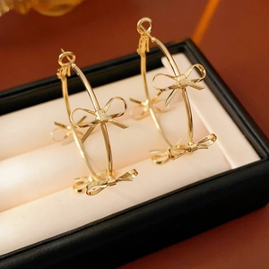 Close-up of golden bow hoop earrings elegantly placed in a jewelry gift box