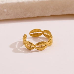 Golden stainless steel adjustable open ring with textured shell patterns on beige background