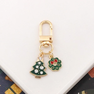 Golden Christmas keychain with green enamel rhinestone tree and festive wreath pendant