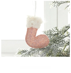 Pink sequined Christmas stocking hanging on snow-covered tree with festive plush detail