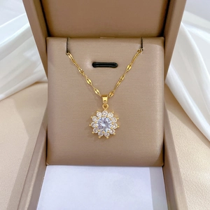 Dettaglio della collana a quadrifoglio dorata con zircone centrale in un portagioie elegante