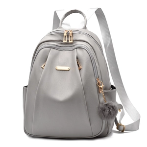 Grey PU leather women's backpack with gold zippers and decorative grey fur ball charm