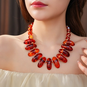 Detail of amber oval beads and gold spacer beads on a vintage minimalist necklace