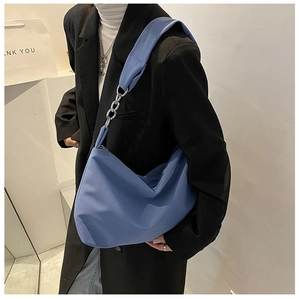 Close-up of blue canvas Hobo bag featuring a stylish metal chain and fabric shoulder strap