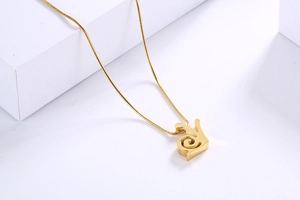 Nahaufnahme der goldenen Schnecken-Halskette mit feiner Schlangenkette auf weißem Grund