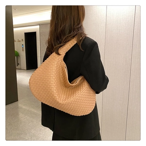 French woven camel leather shoulder bag shown on model for a textured professional look