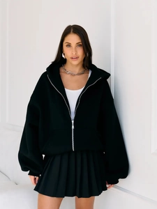 Black hooded zip-up sweatshirt with cartoon print paired with black pleated skirt