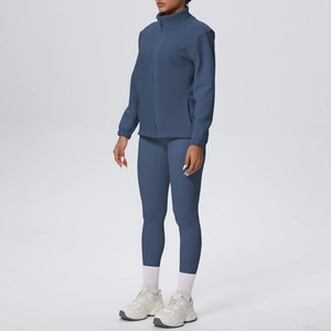 Dettaglio completo del set sportivo grigio-blu con giacca in pile e leggings yoga a vita alta