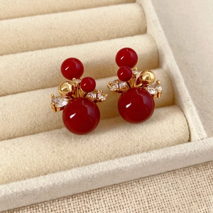 Macro degli orecchini a lobo placcati in oro 18K con perline rosse e zirconi lucidi