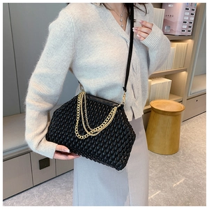 Detailed view of the black pleated cloud bag texture and decorative gold metal chain