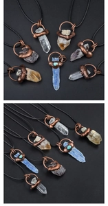 Detailed view of various natural crystal pendants with antique bronze wire wrapping