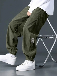 Detail of olive green corduroy cargo joggers showing fabric texture and cuffed hem