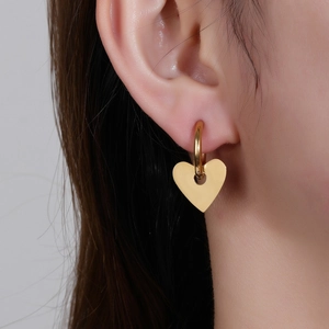 Eleganti orecchini a cuore in acciaio al titanio dorato indossati da una modella