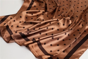 Detail showing the brown silk scarf with black polka dots and fine edge stitching