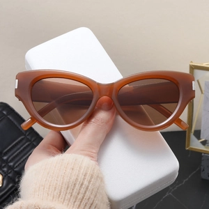 Close-up of amber cat-eye sunglasses with silver metal trim and gradient lenses