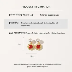 Vue détaillée de la boucle d'oreille dorée avec zircon rouge, perle et dimensions