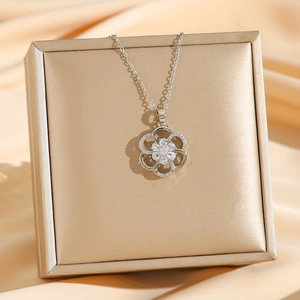 Elegant silver pendant necklace with hollow flower design and sparkling zircon center