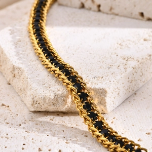 Macro detail of gold chain bracelet featuring black round cubic zirconia inlays
