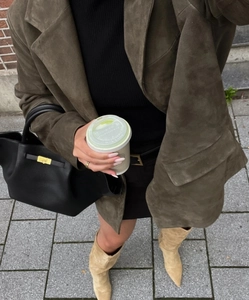 Detailed street style view of retro olive suede jacket texture with elegant accessories