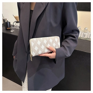 Detailed shot of double-color woven long wallet held by hand in a modern urban setting