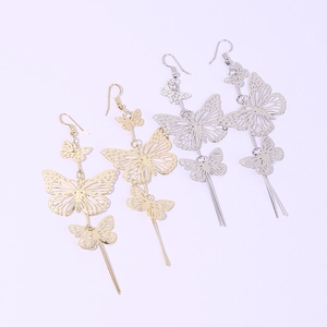 Detailed view of layered hollow butterfly drop earrings in gold and silver metal finishes