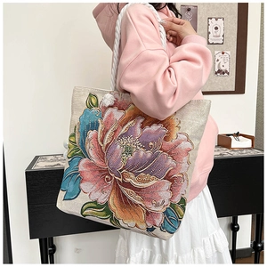 Detailed embroidery of peony flowers and white cotton rope strap on tote bag