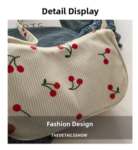 Detail view of white corduroy shoulder bag with vibrant red cherry print and soft texture