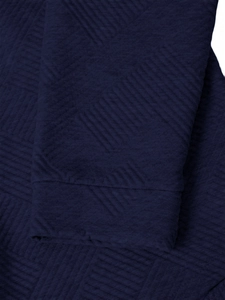 Macro view of navy blue quilted sleeve cuff showing geometric embossed fabric texture