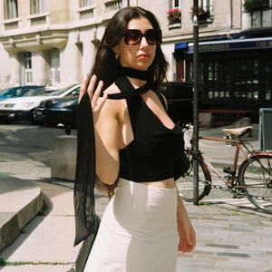Sexy black halter neck crop top with matching skinny tie shown on a European street