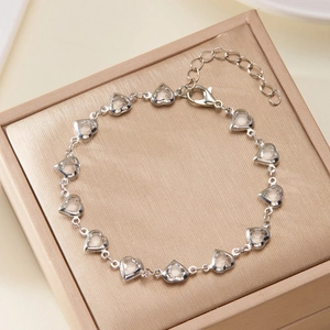 Close-up of silver heart-link bracelet with clear gems inside a jewelry gift box