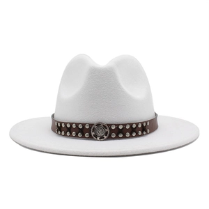 Close-up of white wool felt jazz hat featuring leather band with studs and metal badge